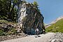 Gravelbiker überqueren eine Kiesstrasse in den Alpen.