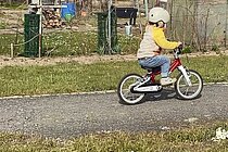 Ein Kind fährt auf einem Kinderad.