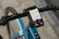Smartphone mit eBike Flow App von Bosch am Lenker eines E-Bikes.