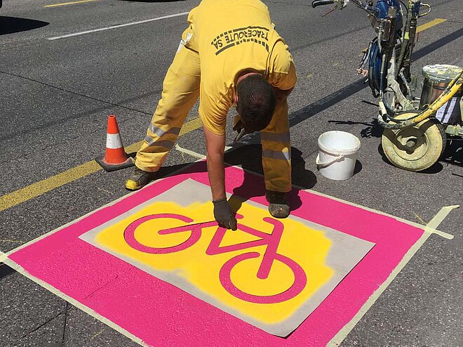 Mit rosa Farbe werden in Genf die neuen Velowege markiert (Foto: Pro Velo Genf). Pop-up-Radweg in Genf